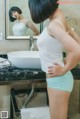 A woman standing in front of a bathroom sink.