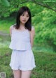 A woman in a blue and white striped top and shorts.