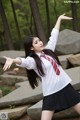 A woman in a school uniform is posing for a picture.