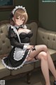 A woman in a maid outfit sitting on a couch.